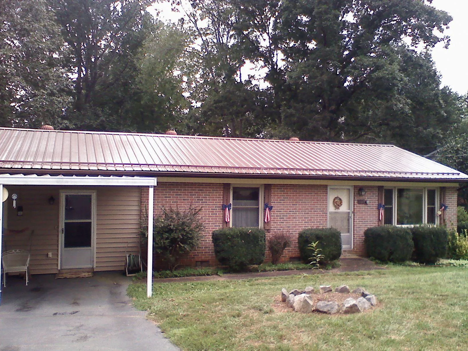 Bronze metal roof and carport on a brick ranch home — Roof Repair work by our crew in Walker